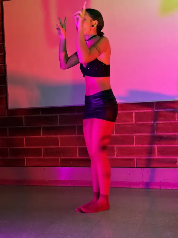 Una actriz de pie bajo luz roja y magenta en el ensayo general