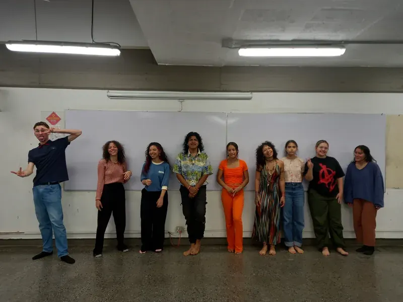 Once integrantes de pie contra el tablero en un calentamiento grupal