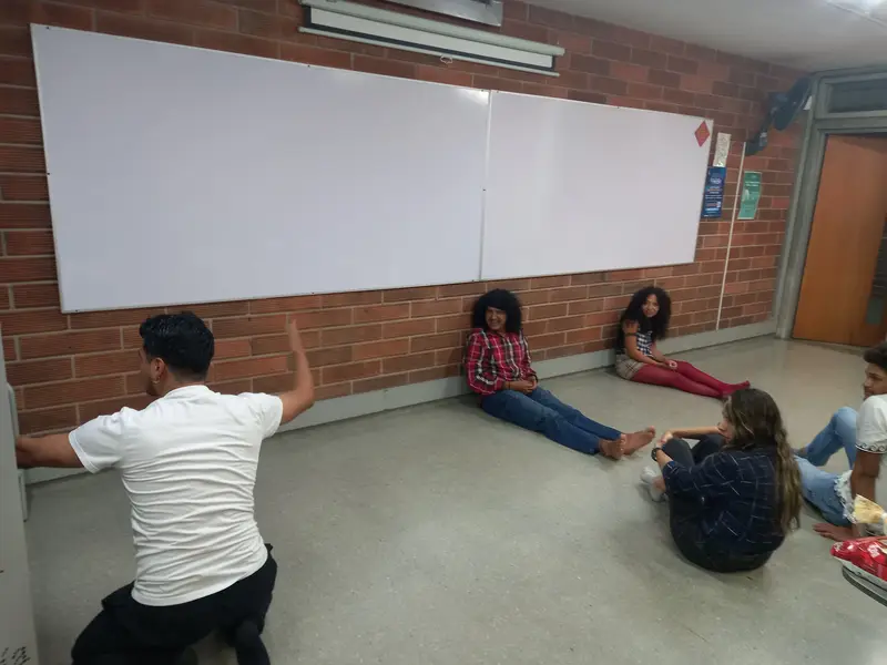 Integrantes recostados contra la pared en un ejercicio grupal