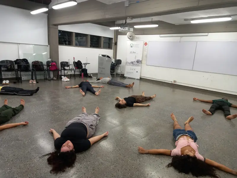 Integrantes tendidos boca arriba en el piso del salón durante una relajación